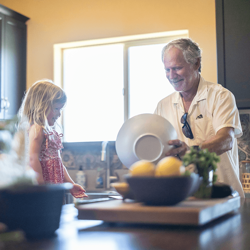 A man and a child making food in a kitchen.