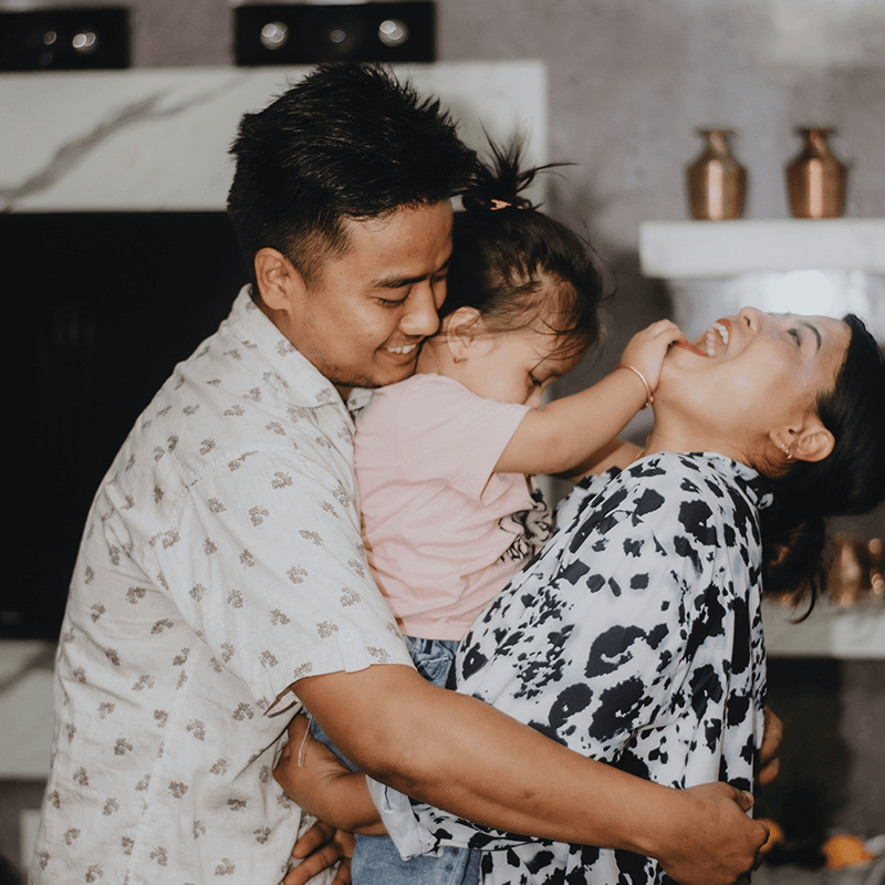 A picture of a family. Two adults and a toddler.
